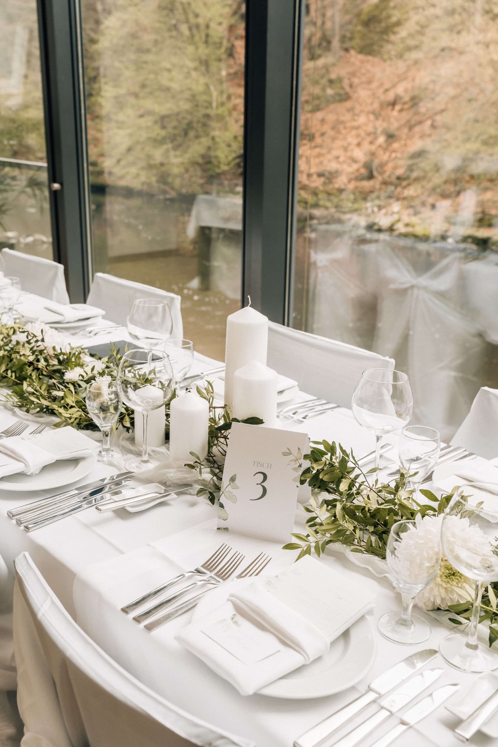 Gedeckte Hochzeitstafel hochkant vor der Fensterfront