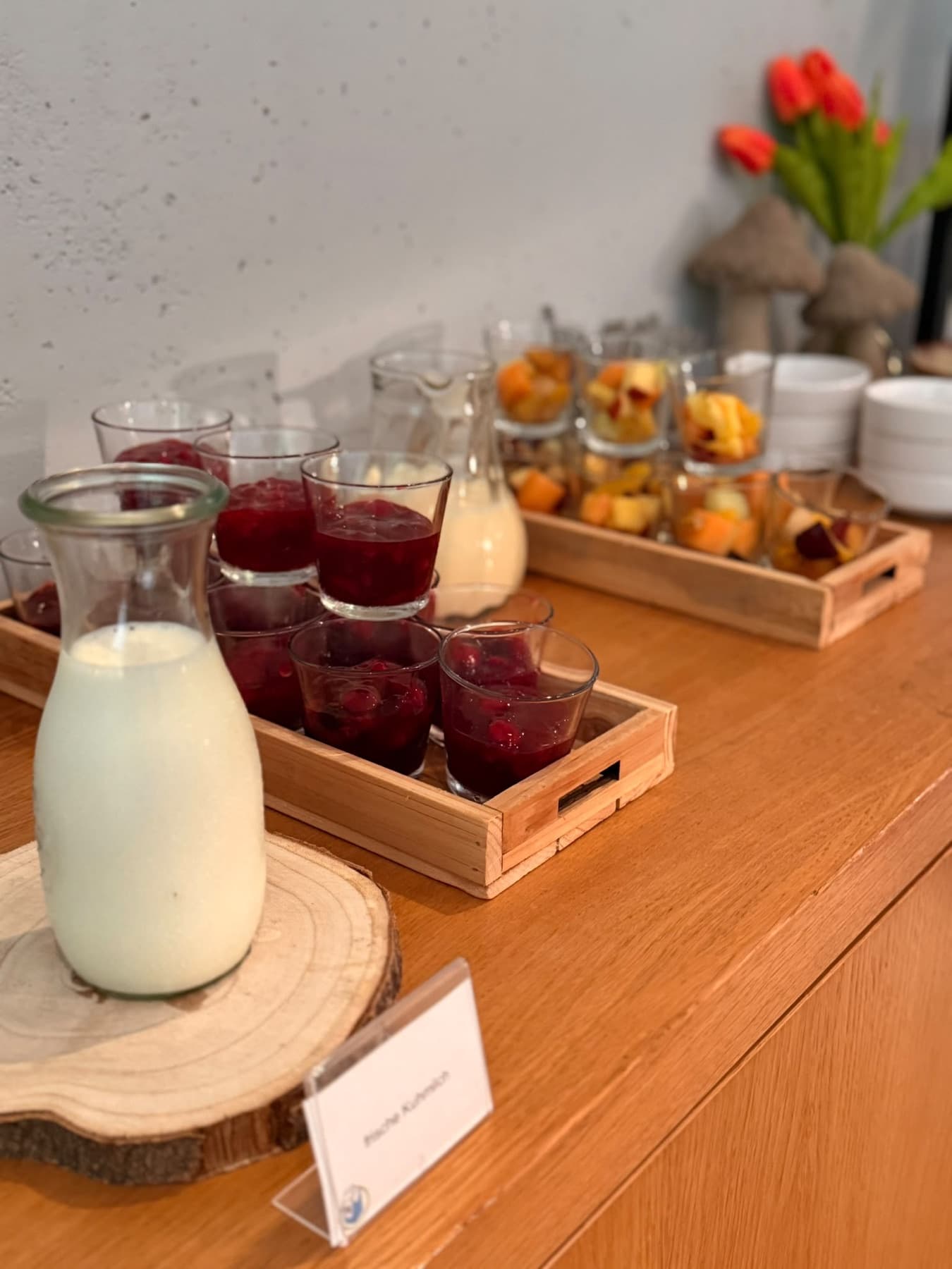 Karaffen mit frischer Milch, Fruchtdessert und Obstsalat im Glas