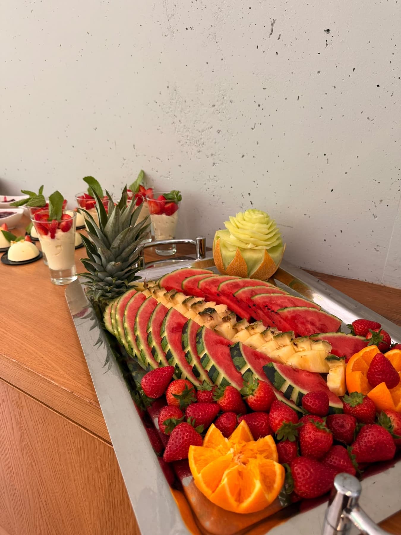 Große Obstauswahl mit kunstvoll geschnittener Melone, Ananas und Beeren